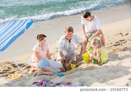 Family with four children playing on beach Family with four children playing on beach 29168773