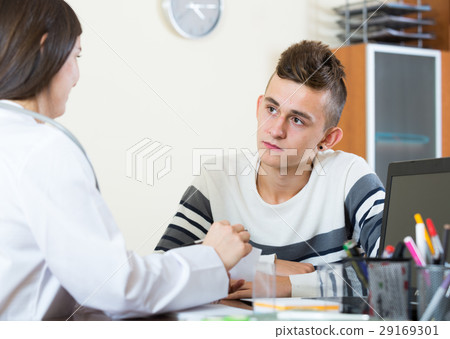 Female doctor questioning teen patient at office 29169301
