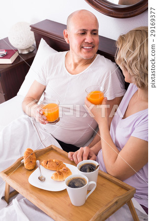 Mature couple having breakfast in bed. Mature couple having breakfast in bed. 29169377