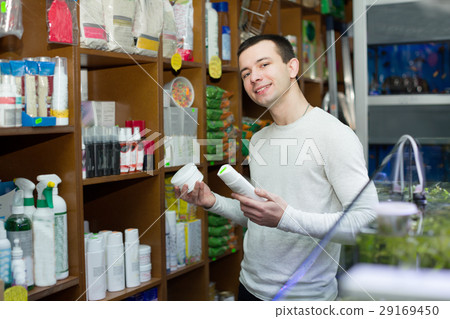 young man with pet supplements in petshop 29169450