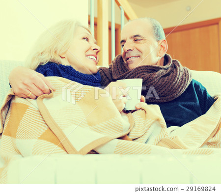 Spouses under blanket drinking tea Spouses under blanket drinking tea 29169824