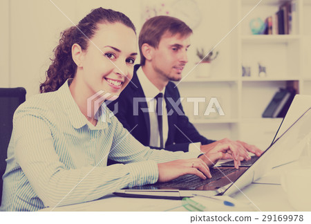 portrait of business woman sitting with laptop on desk in offic 29169978