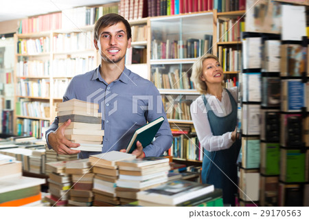 Young smiling man having book pile in hands 29170563