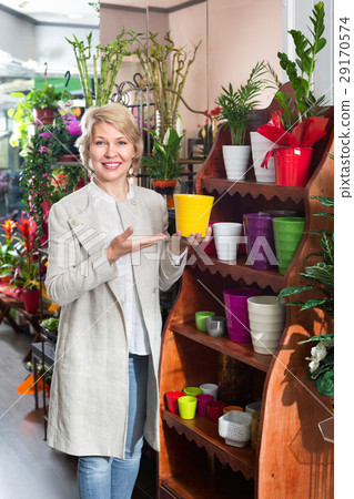 Smiling retiree female customer choosing flower pot 29170574