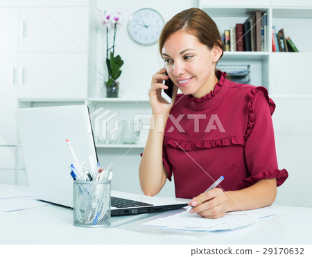 Woman taking notes while talking 29170632