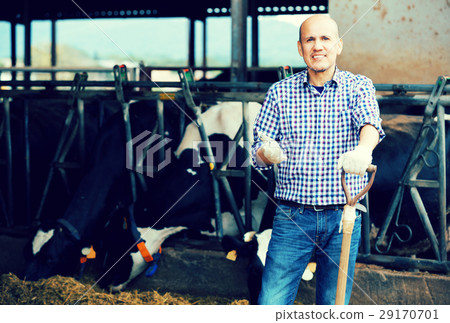 Male farmer holding agricultural tool 29170701