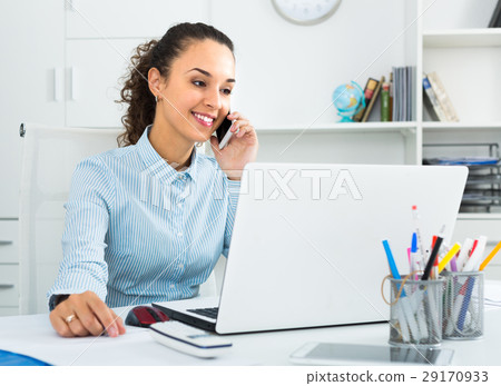 young woman talking by mobile in office. young woman talking by mobile in office. 29170933