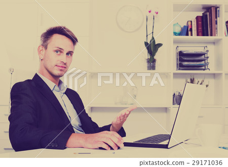 Man at working desk with laptop 29171036