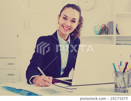 Adult woman working with paperwork and laptop Adult woman working with paperwork and laptop 29171075