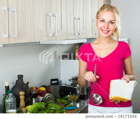 young woman with ladle at kitchen. 29171938