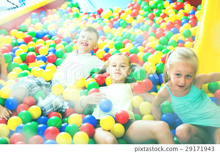 children playing together in pool with plastic multicolored ball children playing together in pool with plastic multicolored ball 29171943