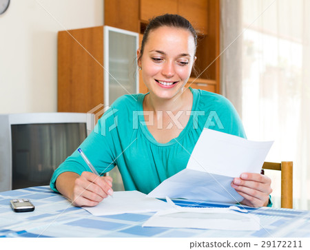 Girl with papers at the table at home 29172211