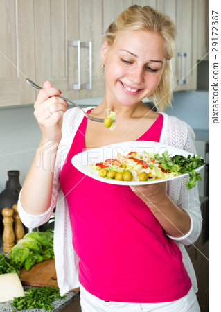 Girl enjoying fresh salad on kitchen 29172387
