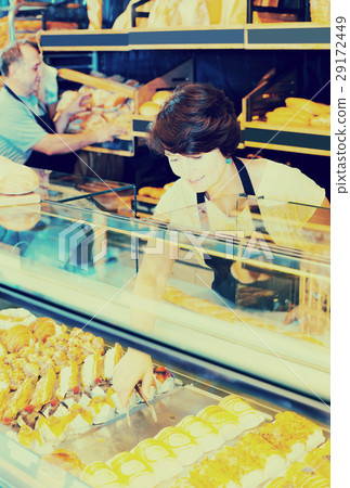 mature female baker with fresh bread in bakery 29172449