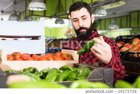 Positive man seller holding sweet peppers Positive man seller holding sweet peppers 29172726