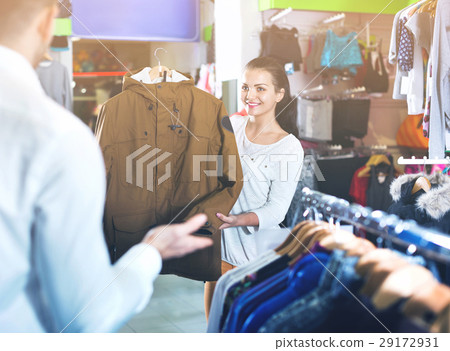Couple examining various coats in sports store 29172931