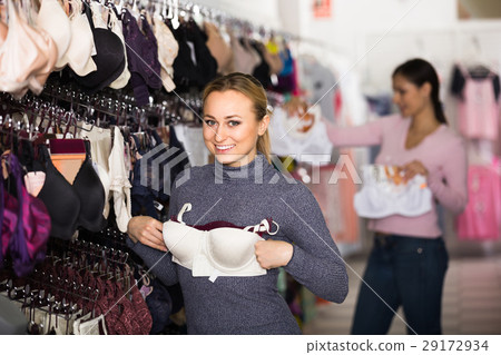 Woman selecting bra in lingerie store. 29172934