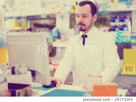 Male pharmacist checking assortment of drugs 29173263