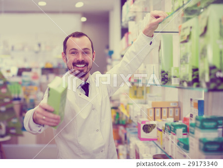Smiling man pharmacist offering right drug 29173340