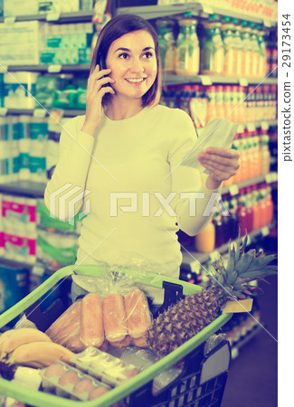 girl consulting on phone about shopping in supermarket 29173454