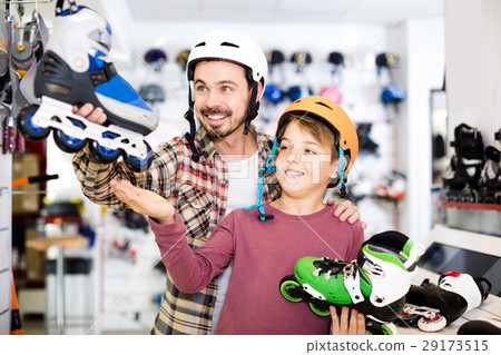 father and son deciding on new roller-skates in sports store 29173515