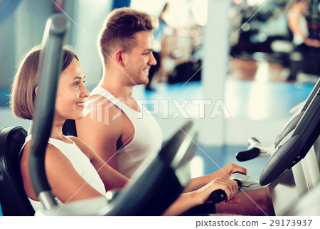 Man and woman workout using cycling cardio machines Man and woman workout using cycling cardio machines 29173937