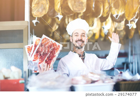 Male shop assistant demonstrating sliced bacon in butcher’s shop Male shop assistant demonstrating sliced bacon in butcher’s shop 29174077
