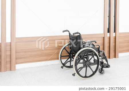 Empty wheelchair parked in hospital hallway 29175001