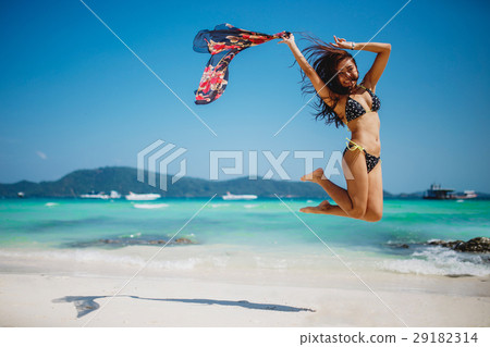 Jumping happy girl on the beach 29182314