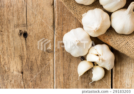 peeled garlic in gunny sack cloth on wooden table peeled garlic in gunny sack cloth on wooden table 29183203