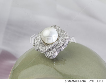 diamond and pearl brooch on green ceramic vase 29184441