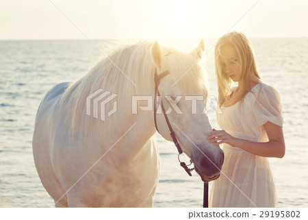 Girl in white dress with horse on the beach Girl in white dress with horse on the beach 29195802