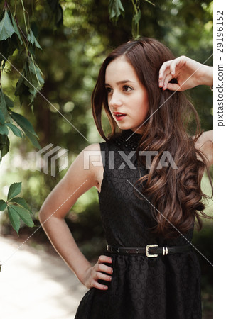 Beautiful young girl in black dress with long hair Beautiful young girl in black dress with long hair 29196152