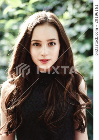 Beautiful young girl in black dress with long hair Beautiful young girl in black dress with long hair 29196161