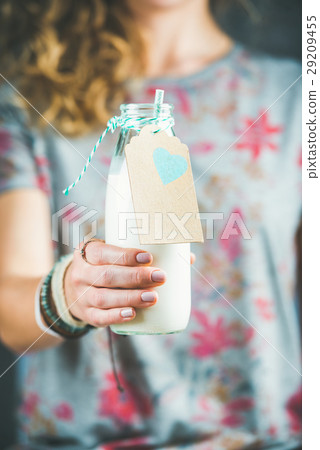 Young woman in t-shirt holding bottle of dairy Young woman in t-shirt holding bottle of dairy 29209455