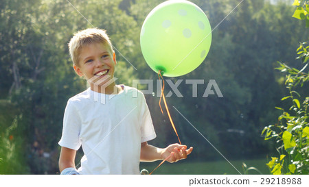 Happy boy holds green balloon having fun with soap Happy boy holds green balloon having fun with soap 29218988