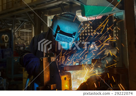 Welder is welding automotive part. 29222074