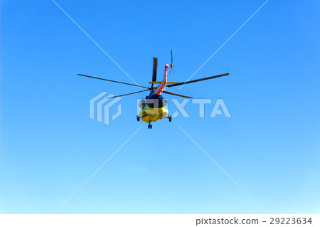 A helicopter flies off in the sky 29223634