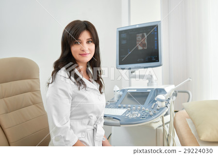 Professional female doctor against ultrasound Professional female doctor against ultrasound 29224030