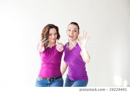 two women in purple clothes show fingers 29229491