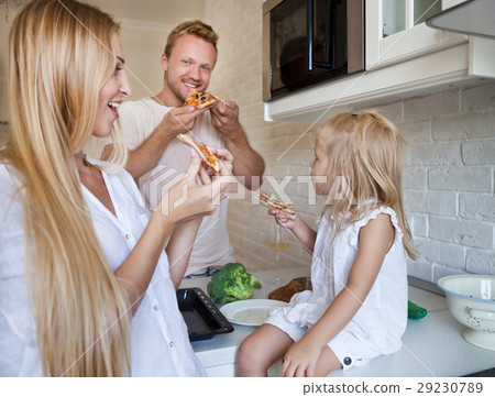 Family eating pizza at home together 29230789