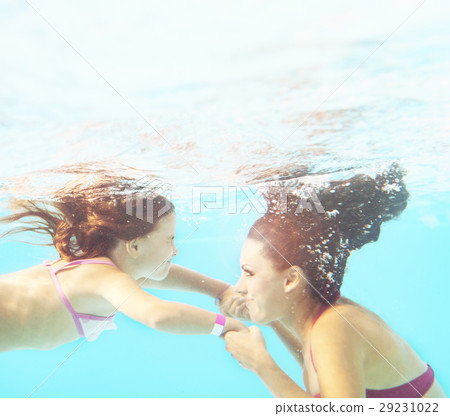 Happy smiling family underwater in swimming pool Happy smiling family underwater in swimming pool 29231022