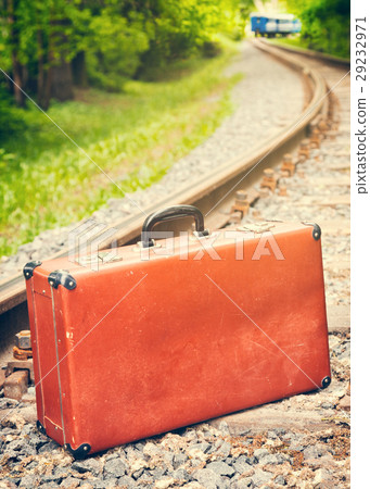 vintage suitcase on the railway, blue train is off 29232971