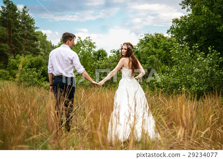 young couple in the ears of wheat in forest 29234077