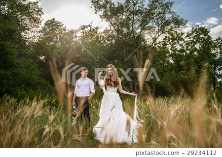 young couple in the ears of wheat in forest young couple in the ears of wheat in forest 29234112
