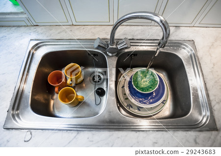 washing of dirty dishes in kitchen sink 29243683