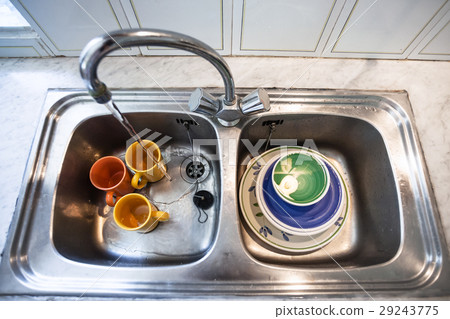 washing of dirty cups in kitchen sink 29243775