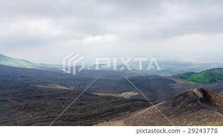 clouds over black lava field on Mount Etna 29243778