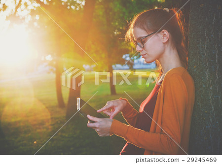 girl holding digital tablet pc at park girl holding digital tablet pc at park 29245469