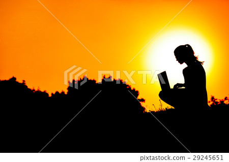 silhouette of a girl with laptop on sunset 29245651